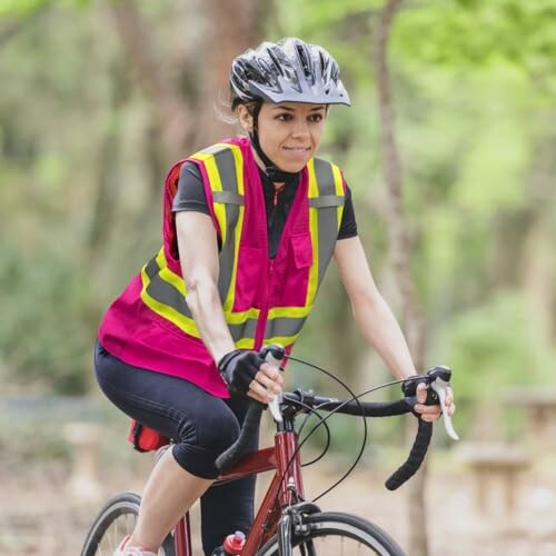 Woman cycling in a safety vest and helmet in a park